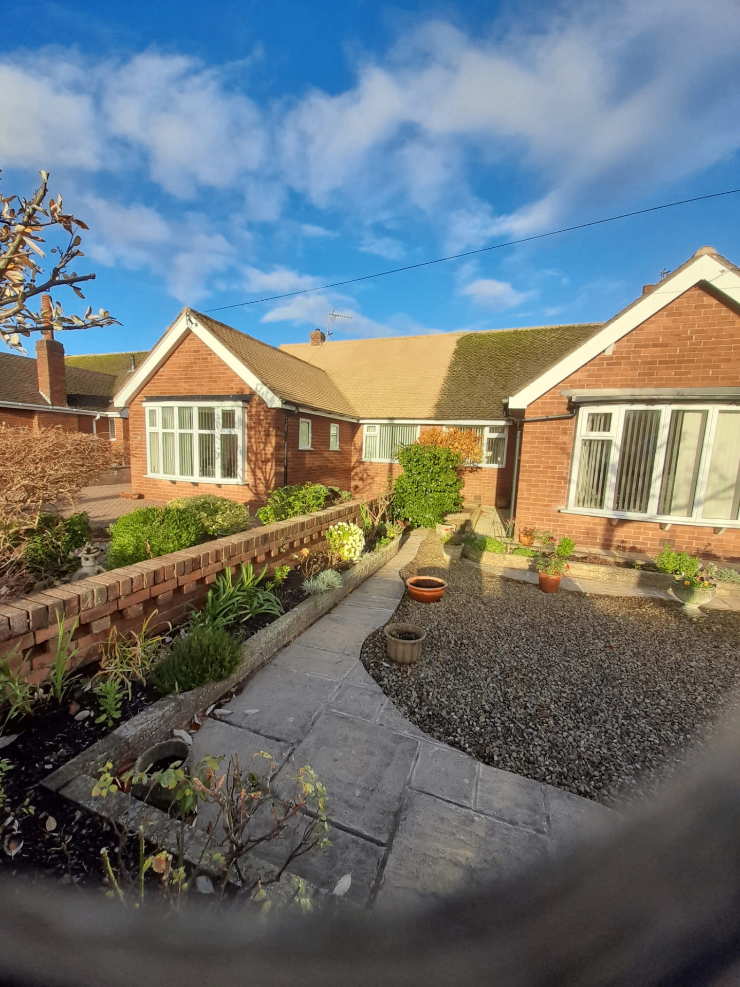 Pair of red brick bungalows with front garden and paved path Preston