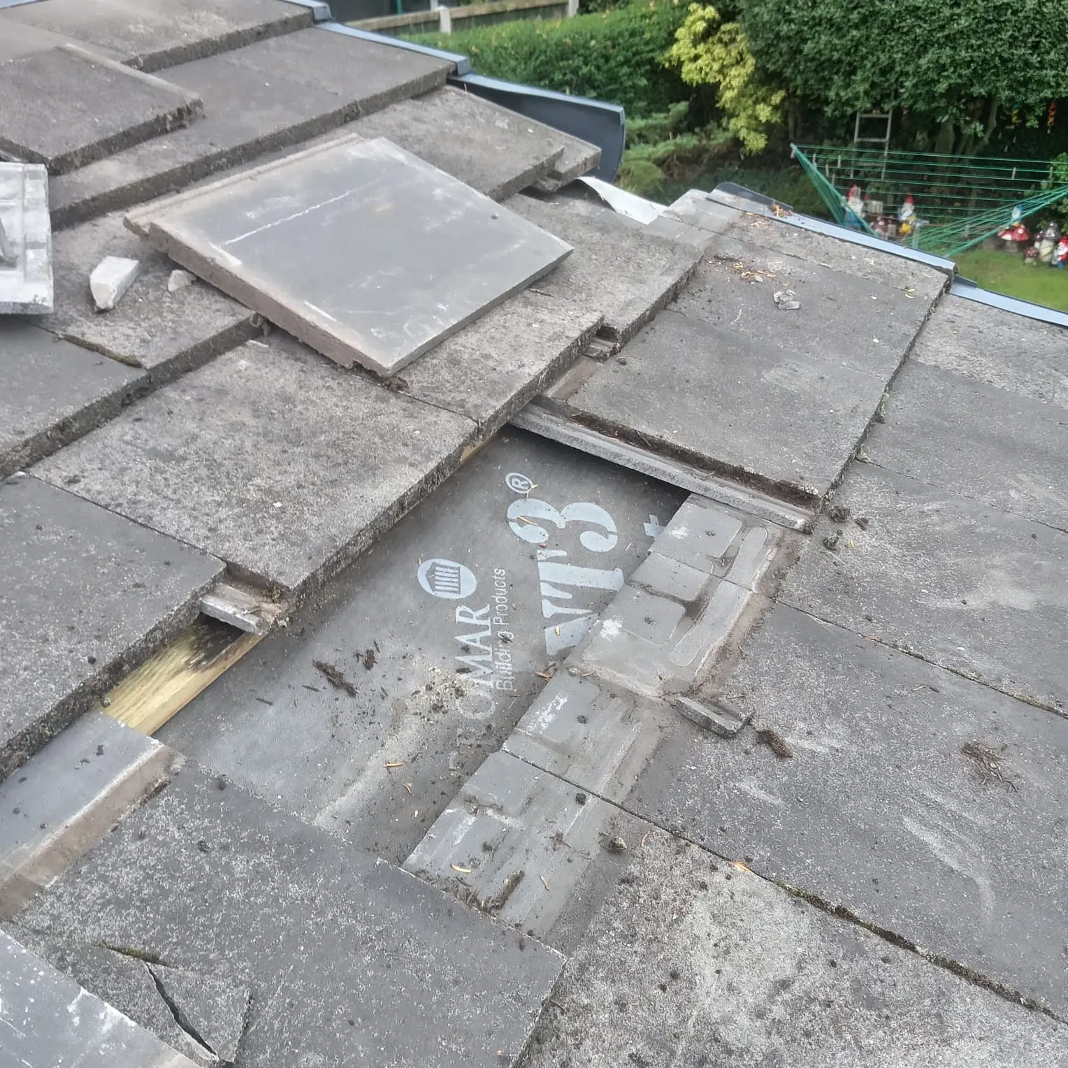 Slipped concrete roof tiles and exposed battens before roof repair Preston