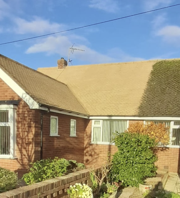 Close-up of cleaned bungalow roof tiles and moss-free section Preston