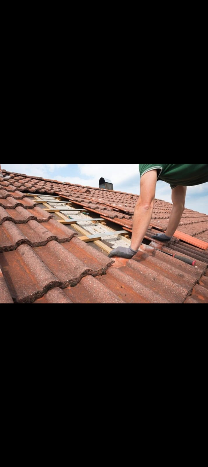 Roofer replacing broken roof tiles and battens on pitched tile roof Preston