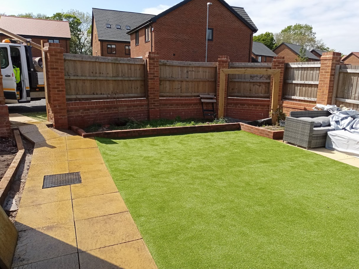 Artificial grass lawn with brick wall